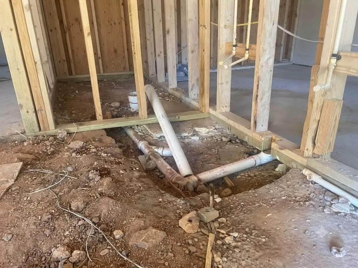 Basement floor trenched open around the main drain line before a backwater valve is set in place